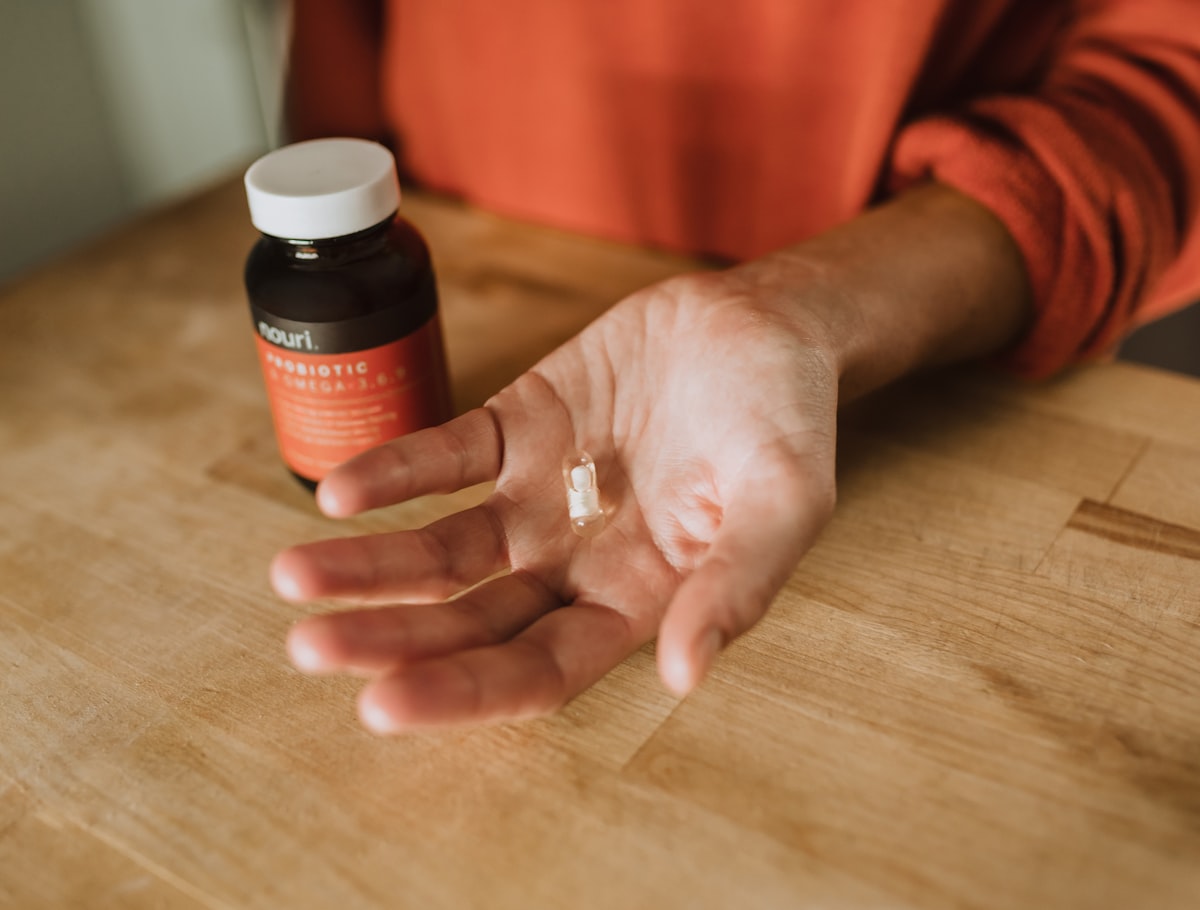 A woman holding a supplement capsule